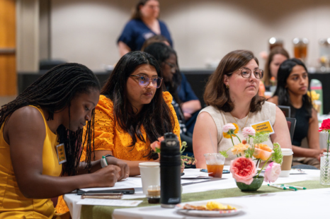 Erika Moore, Jenna Mueller, and another conference attendee sit together