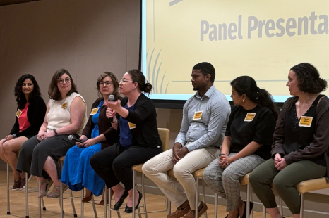 A group of panelists sit at the front of a room