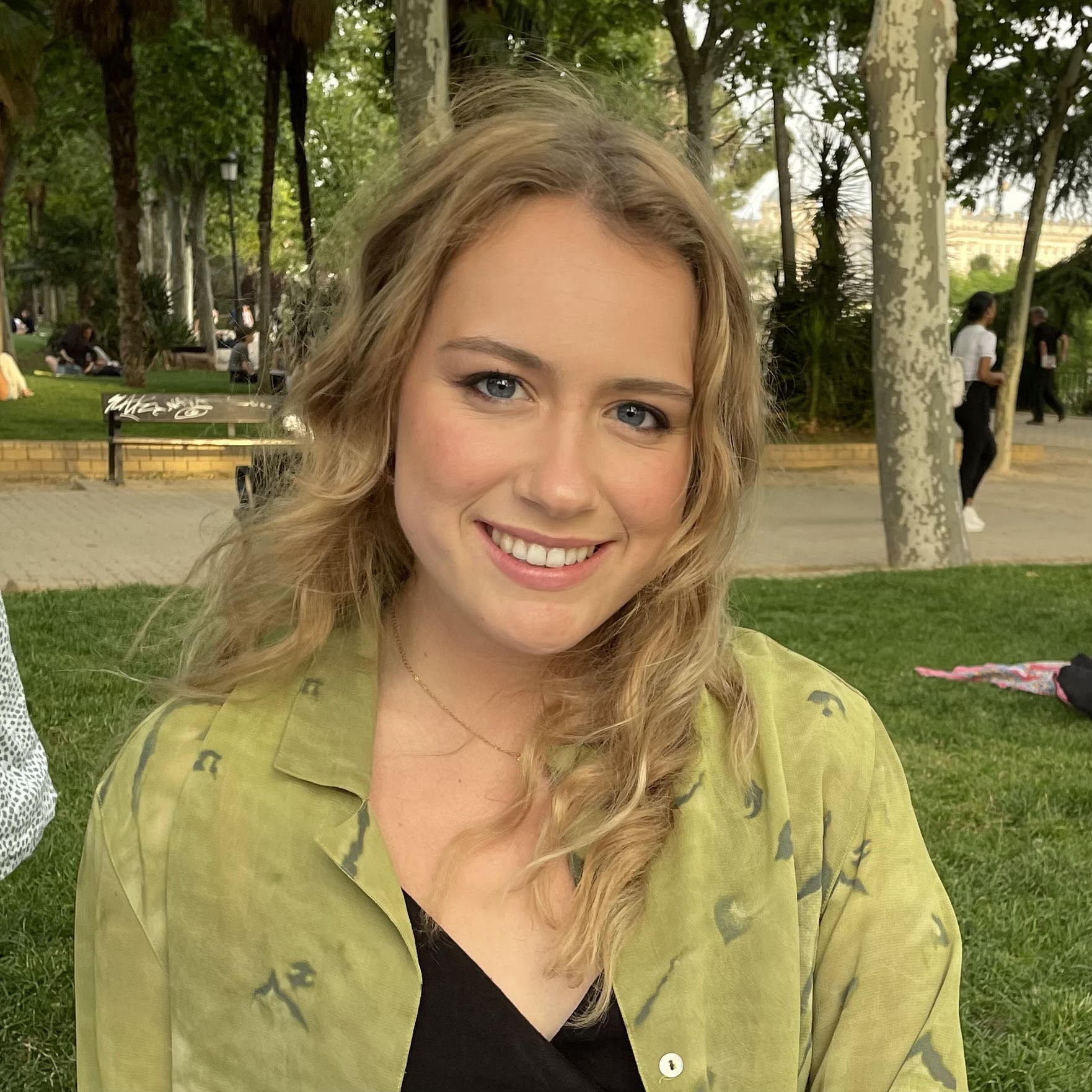 Anne Barnes, a graduate student in Jenna Mueller’s lab, smiles for a portrait outdoors in a park.