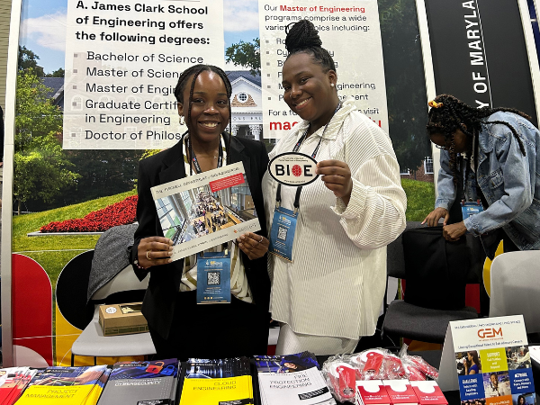 Two Bioengineering students pose at a conference booth.