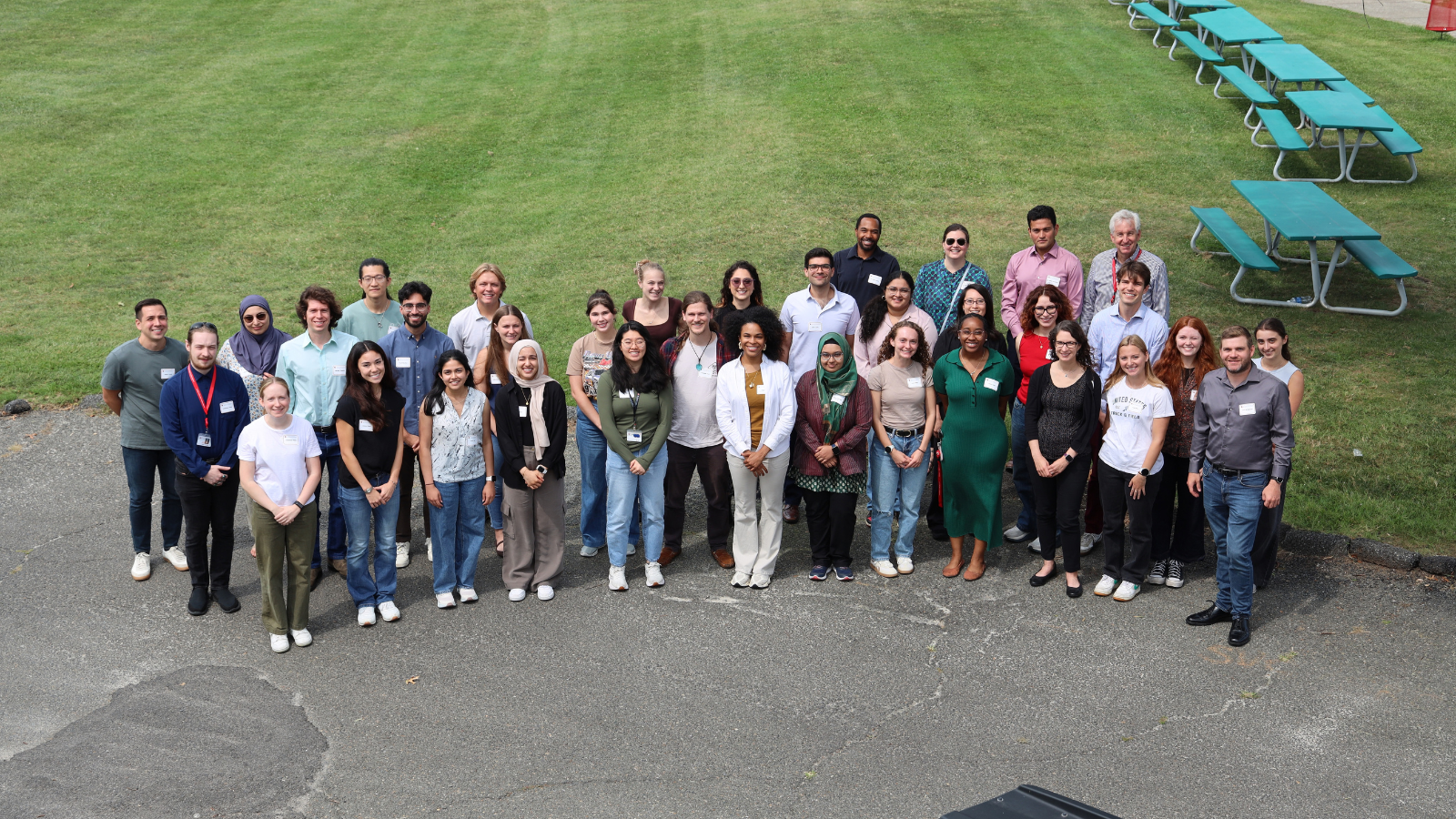 Group photo of EPIC Retreat 2026 attendees standing together outdoors on a paved area near a grassy field.