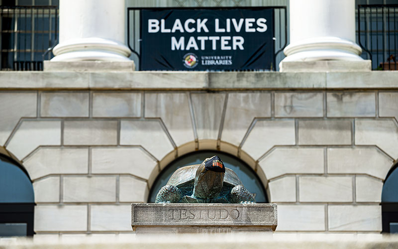 A Black Lives Matter sign hangs out front of McKeldin Library, behind the Testudo satute